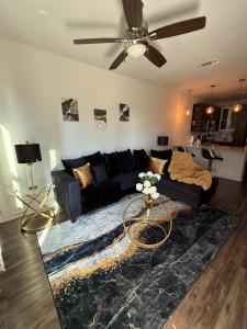 ein Wohnzimmer mit einem schwarzen Sofa und einem Deckenventilator in der Unterkunft 1B1B Luxury with City view in Dallas