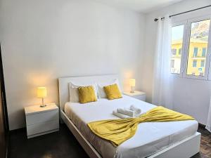 una camera da letto con un letto con cuscini gialli e una finestra di Villa Herédia - 5 min form the beach a Ribeira Brava