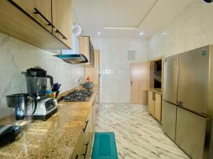 una cocina con refrigerador y encimera en Home away from Home, en Lekki