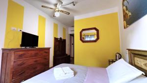 a bedroom with yellow walls and a bed with a television at Casetta La Rubiconda in Asti