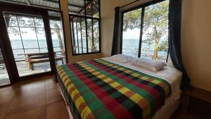 a bedroom with a bed with a view of the ocean at Finca Ometepe in Balgue