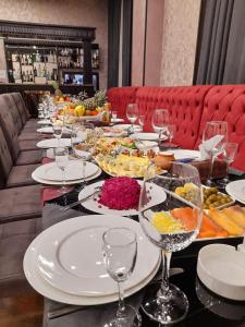 a long table with plates of food and wine glasses at VIAGGIO Yerevan in Yerevan