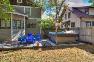 Eine Frau steht auf einer Terrasse im Garten neben einem Whirlpool. in der Unterkunft 615 Ash Avenue - Modern Retreat w Hot Tub in Ames