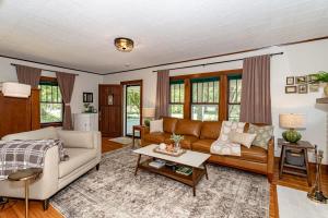 ein Wohnzimmer mit Sofa und Tisch in der Unterkunft 615 Ash Avenue - Modern Retreat w Hot Tub in Ames