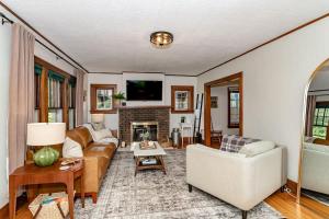 ein Wohnzimmer mit Couch und Kamin in der Unterkunft 615 Ash Avenue - Modern Retreat w Hot Tub in Ames