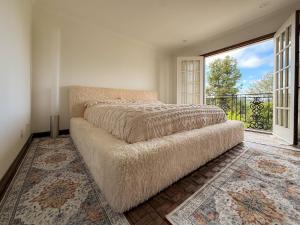 a bedroom with a bed and a large window at Vista Villa – Poolside Elegance with Views in Sherman Oaks +56 photos