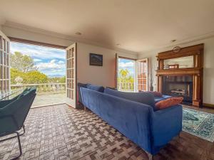 a living room with a blue couch and a fireplace at Vista Villa – Poolside Elegance with Views in Sherman Oaks