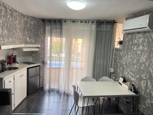 a kitchen with a white table and chairs and a window at Estudio Loft in La Pineda