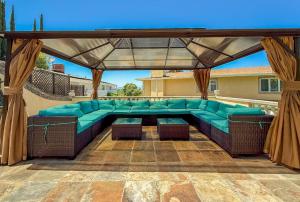 a patio with a blue couch under a gazebo at Vista Villa – Poolside Elegance with Views in Sherman Oaks