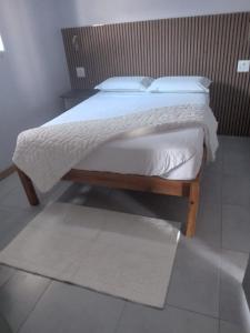 a bedroom with a bed with white sheets and pillows at Siyaya’s Guest Palace in Jozini