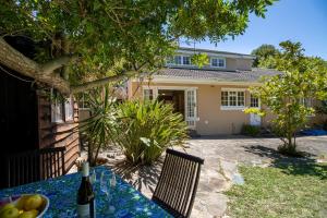 einen Tisch mit einer Flasche Wein vor einem Haus in der Unterkunft Constantia Retreat with Pool & Garden in Doordrift