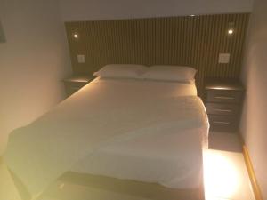 a bedroom with a large bed with white sheets and pillows at Siyaya’s Guest Palace in Jozini