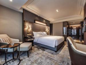 een hotelkamer met een bed, een tafel en stoelen bij Mercure Chongqing Downtown in Chongqing +92 foto's