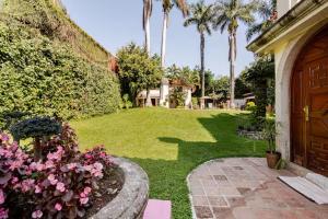 a house with a yard with palm trees and a door at Quinta San Francisco in Cuernavaca
