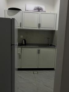 a kitchen with white cabinets and a refrigerator at روڤان in Hafr Al-Batin +16 photos