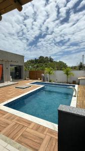 a swimming pool in a backyard with a wooden deck at Recanto das Guerreiras in Marau