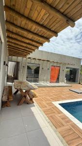 a patio with a picnic table and a swimming pool at Recanto das Guerreiras in Marau +4 photos
