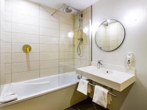 a bathroom with a sink and a tub and a mirror at ibis Styles Paris Meteor Avenue d'Italie in Paris