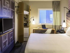 a bedroom with a bed and a desk with a laptop at ibis Sao Paulo Tatuape in Sao Paulo