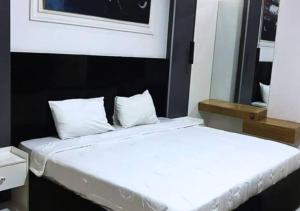 2 camas blancas en una habitación con espejo en Home away from Home, en Lekki