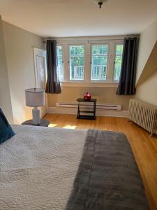 a bedroom with a large bed and two windows at Midstream Manor Unit 8 - 2 Bedroom Apartment in St. John's