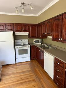 a kitchen with white appliances and wooden cabinets at Midstream Manor Unit 9 - 2 Bedroom Apartment in St. John's +4 photos