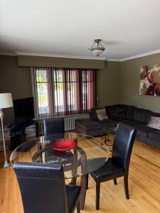 a living room with a glass table and chairs at Midstream Manor Unit 9 - 2 Bedroom Apartment in St. John's