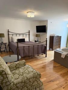 a bedroom with a bed and a couch and a tv at The Baffin Apartment - 2 Bedroom Apartment in St. John's