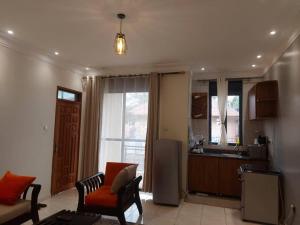 a kitchen with a couch and a chair in a room at The Fancy convenience-free wifi Kyanja in Kampala