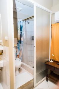 a bathroom with a shower and a toilet at La Casa Naranja Hostal in Olón +127 photos
