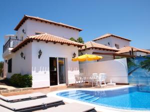 uma villa com uma piscina e uma casa em Villa Chayofa Sunrises em Chayofa