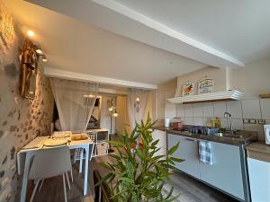 una pequeña cocina con mesa y barra en La Grotte Provençale à Sisteron, en Sisteron