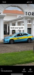 a blue and yellow car parked in front of a building at Taxi driver in Espargos