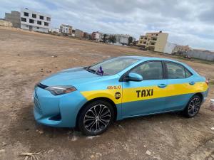 a blue and yellow taxi car parked in a field at Taxi driver in Espargos