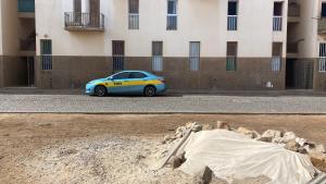 a blue and yellow car parked in front of a building at Taxi driver in Espargos