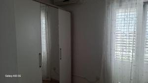 a white room with a window and a curtain at Apartmani Kunjasic in Trstenik +45 photos