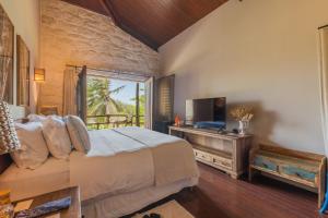 ein Schlafzimmer mit einem Bett und einem Flachbildfernseher in der Unterkunft Casa de Pedra Hotel Icaraizinho in Icaraí