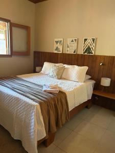 a bedroom with a bed with white sheets and a mirror at Recanto no Centro in São Francisco Xavier