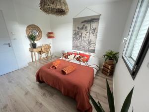 een slaapkamer met een bed met oranje kussens erop bij Maison avec terrasse en bois et piscine in Varaire +65 foto's