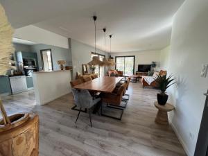 een keuken en eetkamer met een tafel en stoelen bij Maison avec terrasse en bois et piscine in Varaire