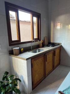 a kitchen with a sink and a stove in it at Recanto no Centro in São Francisco Xavier