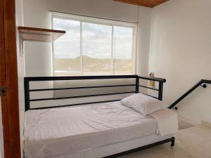 En eller flere senge i et værelse på Plaza Blanca 2 cabaña en el Santorini Colombiano