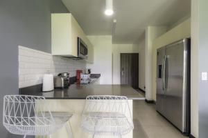 a kitchen with a refrigerator and two chairs in it at Corporate Stays Urban Flats Studio in Lagunilla