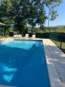ein großer blauer Swimmingpool mit Stühlen und Bäumen in der Unterkunft Villa Berhartia in Cambo-les-Bains