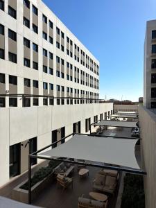 een uitzicht op een gebouw met stoelen en een tafel bij Yugo Terrassa Can Telar in Terrassa +7 foto's