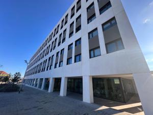 een groot wit gebouw met veel ramen bij Yugo Terrassa Can Telar in Terrassa