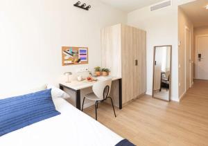een slaapkamer met een bed en een bureau en een kamer bij Yugo Terrassa Can Telar in Terrassa