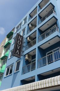 a blue apartment building with a sign on it at Nova Patong in Patong Beach