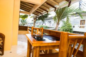a table and chairs on a balcony with palm trees at La Casa Naranja Hostal in Olón