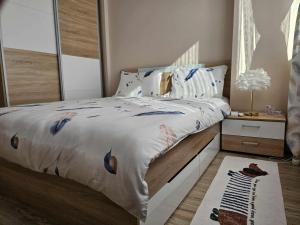 ein Schlafzimmer mit einem Bett mit einer weißen Bettdecke in der Unterkunft Apartment Bee Happy, Pchelinski Bani in Pchelin